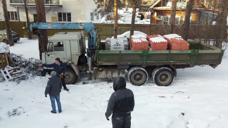 Грузовик с кирпичом на зимней стройплощадке