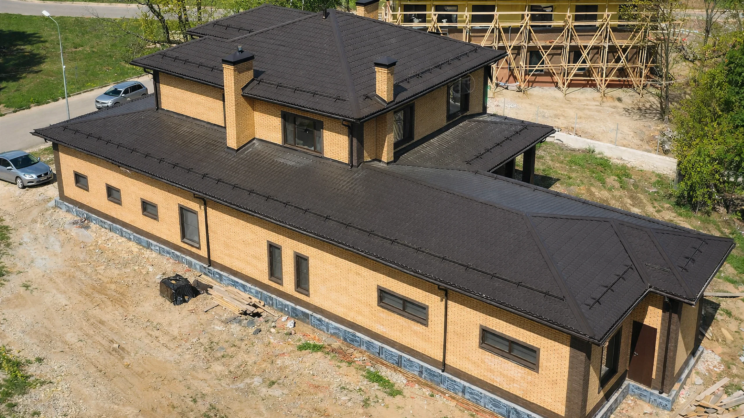 Аэрофото двухэтажного дома 382 м² с протяженной кровлей, гаражным крылом и кирпичным фасадом