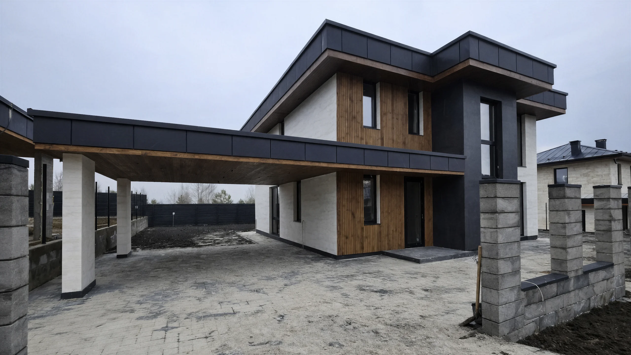 Боковой вид двухэтажного дома 240 м² с крытым навесом, деревянной отделкой и серыми фасадными акцентами